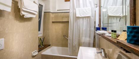 Un baño con bañera, lavabo e inodoro.