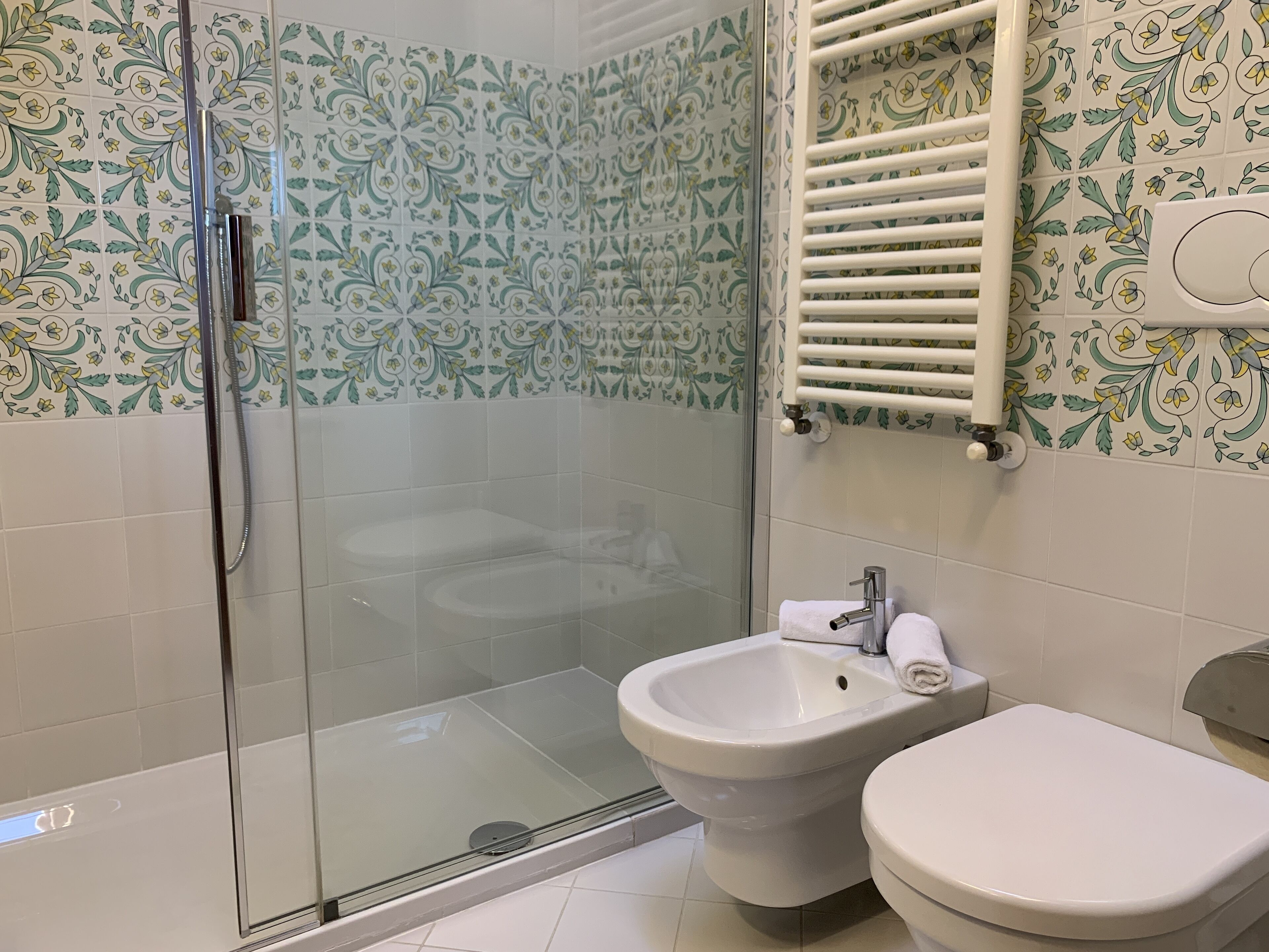 Un baño con cabina de ducha de vidrio, un bidé y un inodoro.