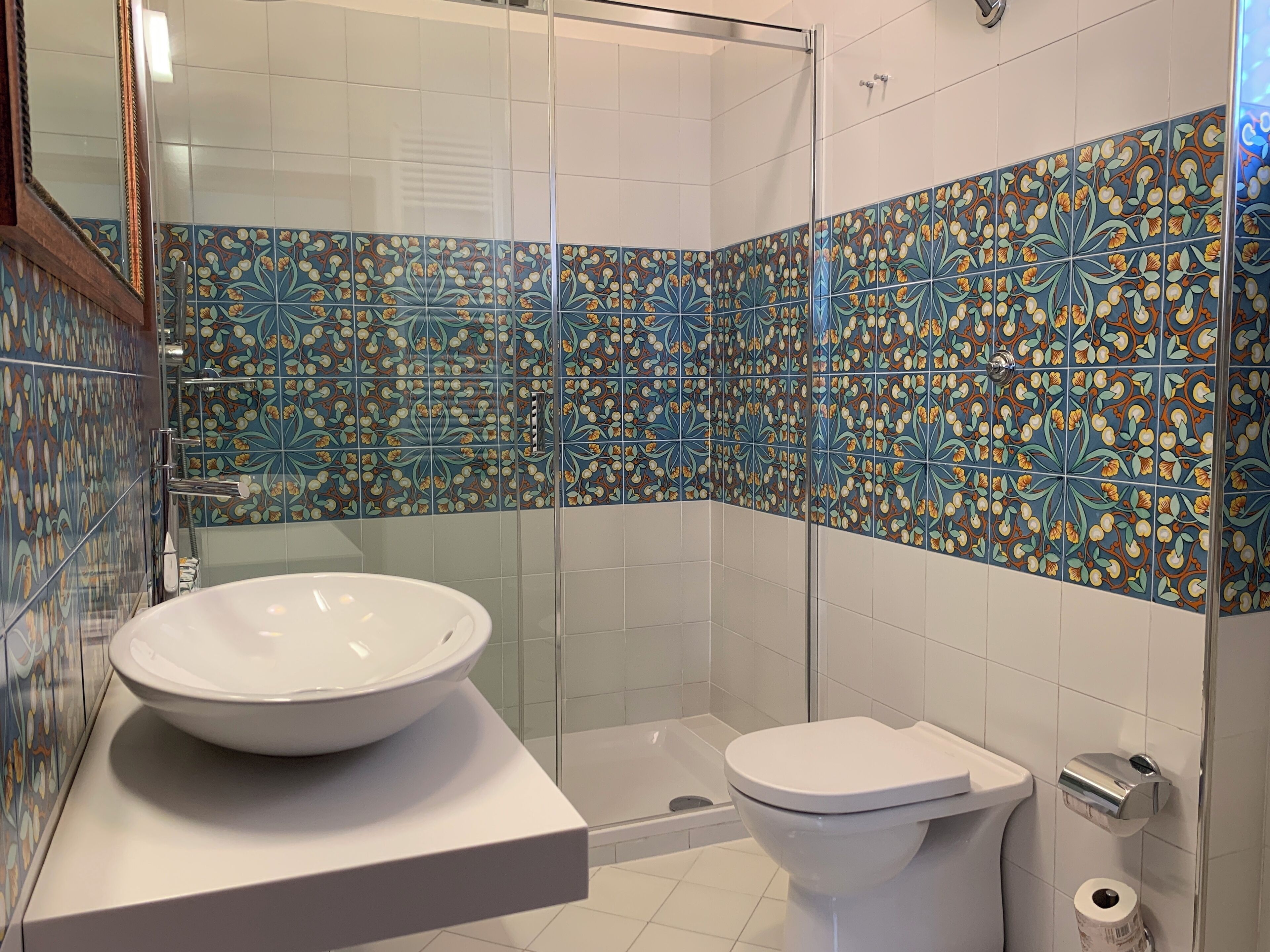 Un baño con un lavabo grande blanco, inodoro y zona de ducha.