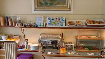A breakfast buffet setup with various food items, a toaster, and a coffee machine.
