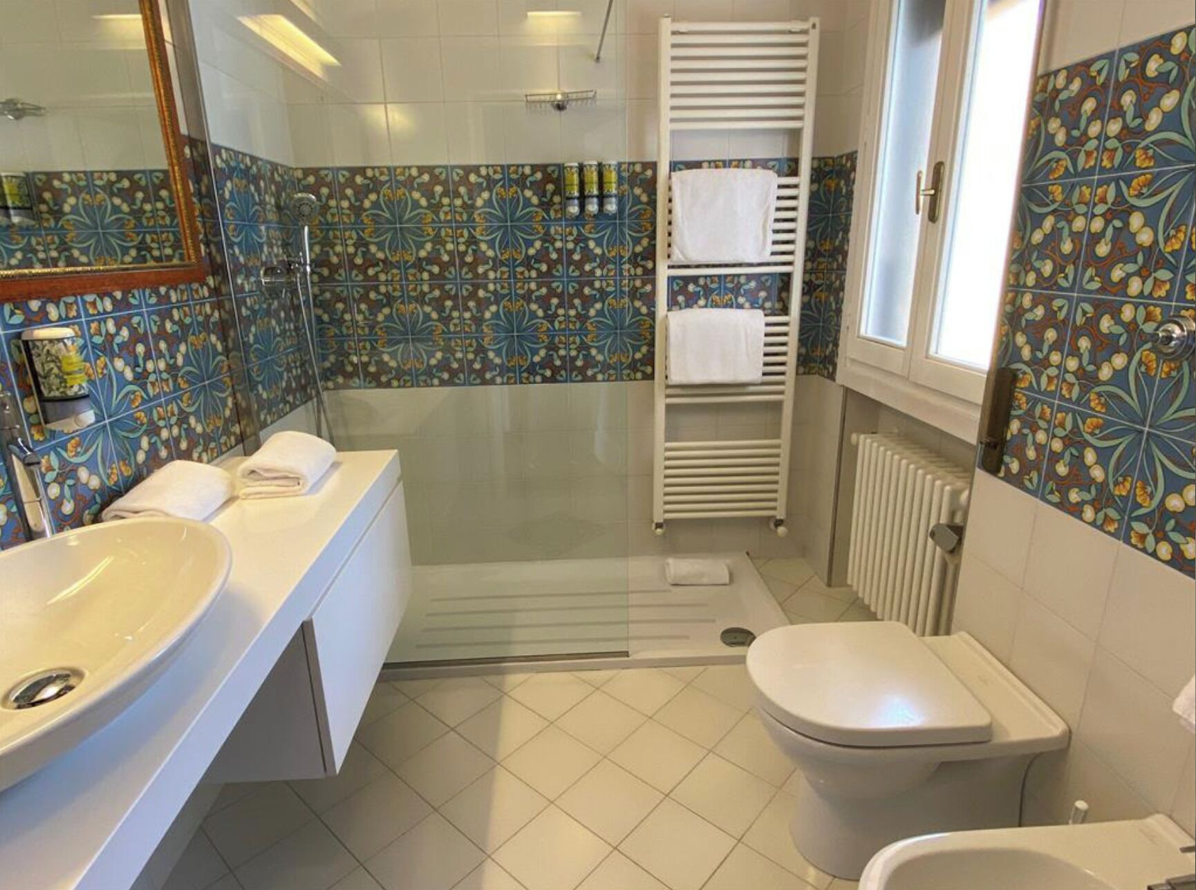 Un baño con un lavamanos grande, inodoro y zona de ducha.