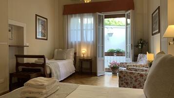 Una camera d'albergo con un letto, una sedia, un tavolo, una lampada e vista all'esterno.