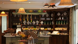 A buffet setup with various food items and a selection of bottles in the background. - Hotel Ville sull'Arno - Preferred Hotels & Resorts (Florence)