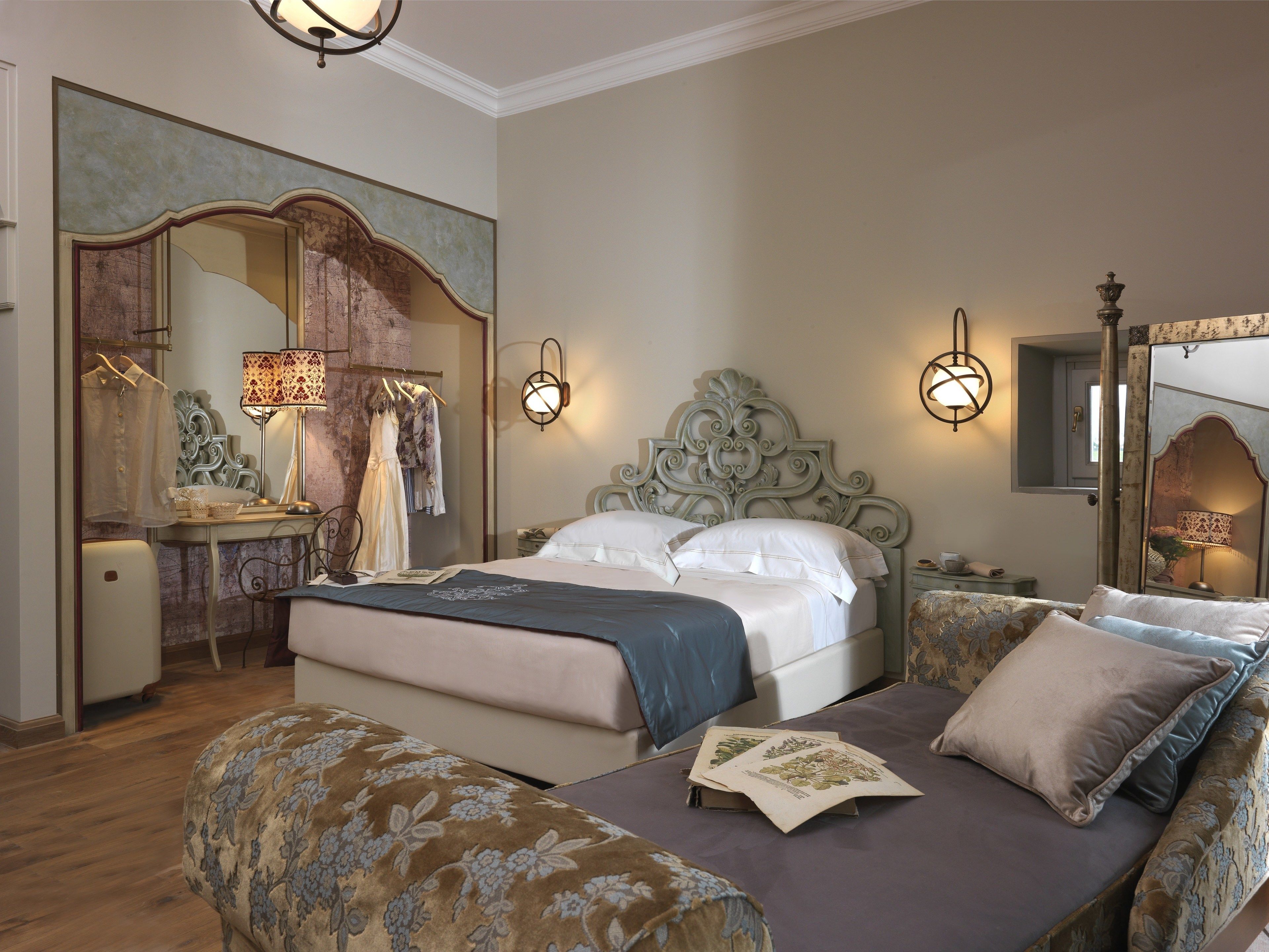 Een slaapkamer met een bed, nachtkastje, dressoir en spiegel.
