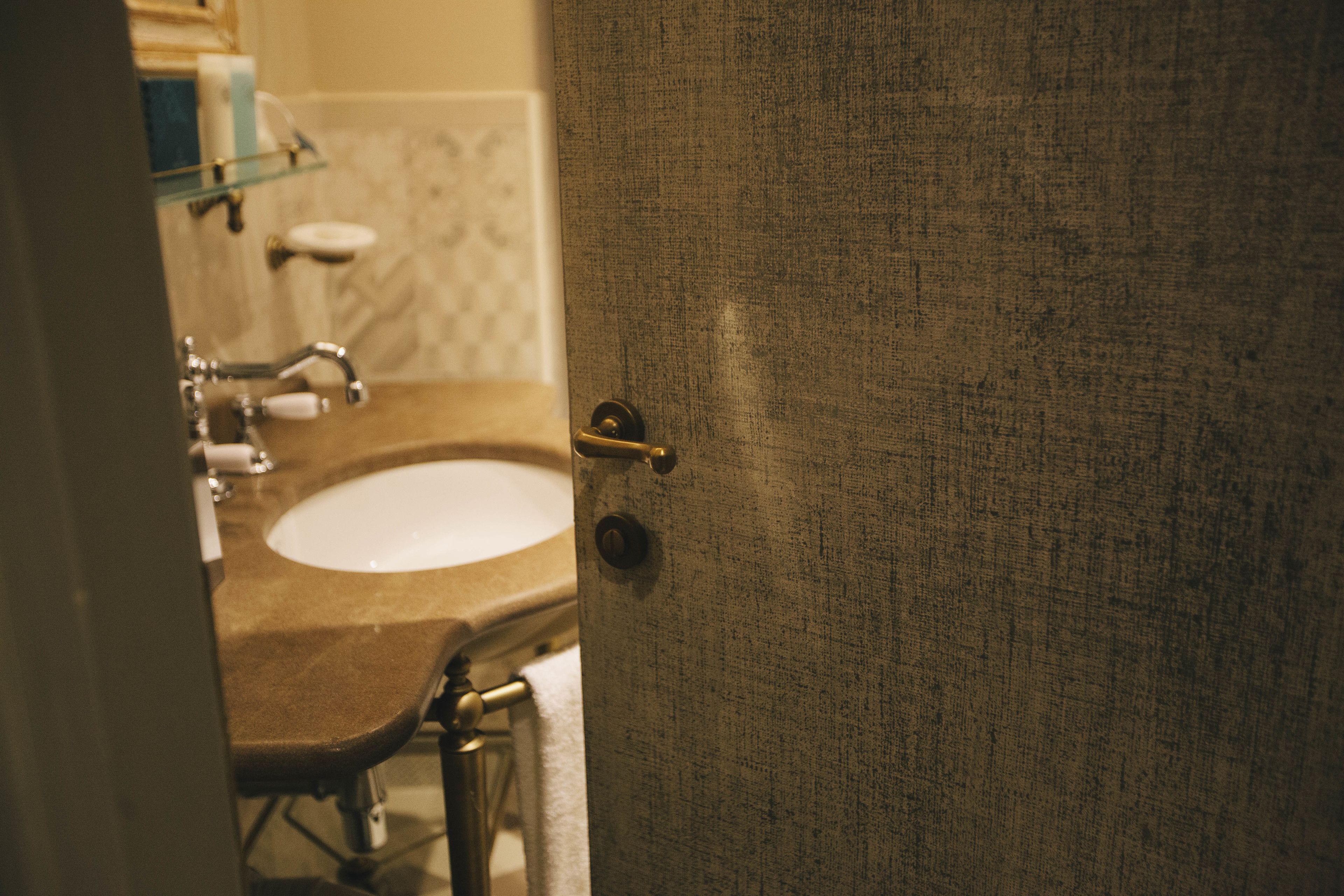 A bathroom with a sink, mirror, and towel rack.