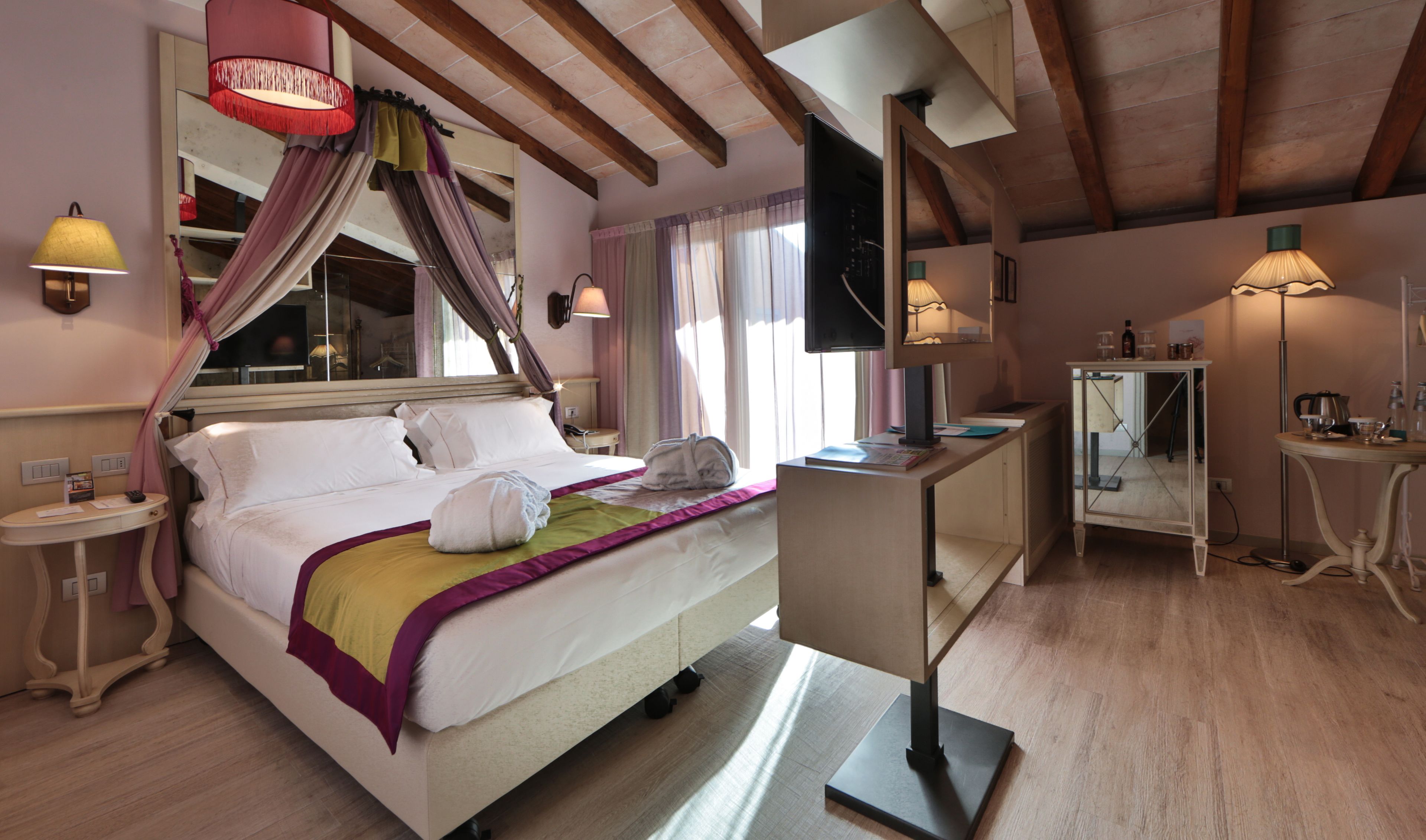Un dormitorio elegante con una cama grande, un escritorio y un televisor.