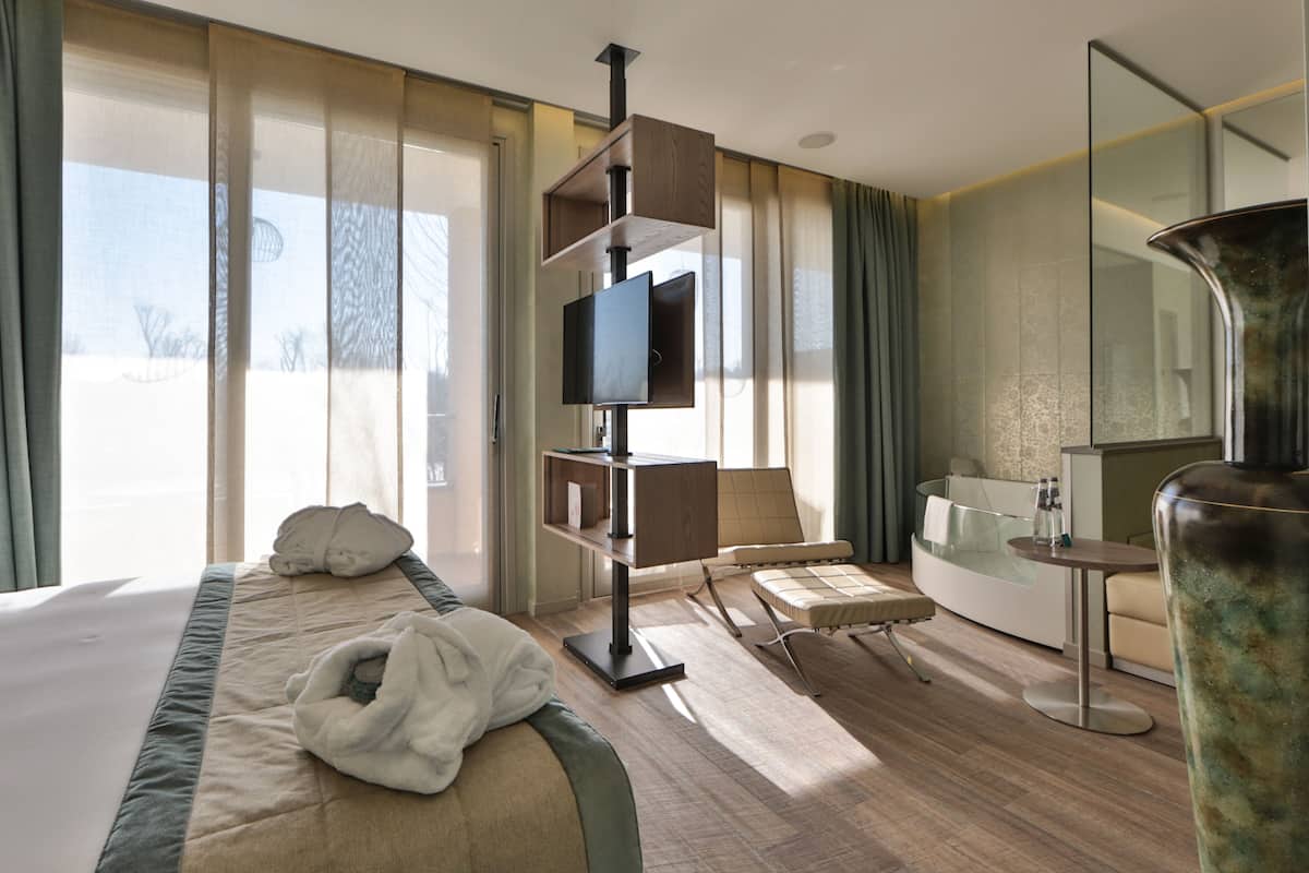 junior room, hot tub, river view (private wellness resort) | 1 bedroom, down duvets, minibar, in-room safe