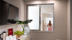 Ein Hotelbad mit einem großen Spiegel, einem Fenster, einem Waschbecken und einem Handtuchhalter.
