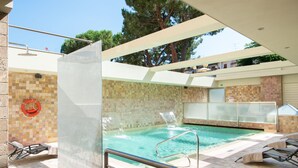 Ein Pool im Freien mit Glasveranda, Liegestühlen und einem Rettungsring an der Wand.