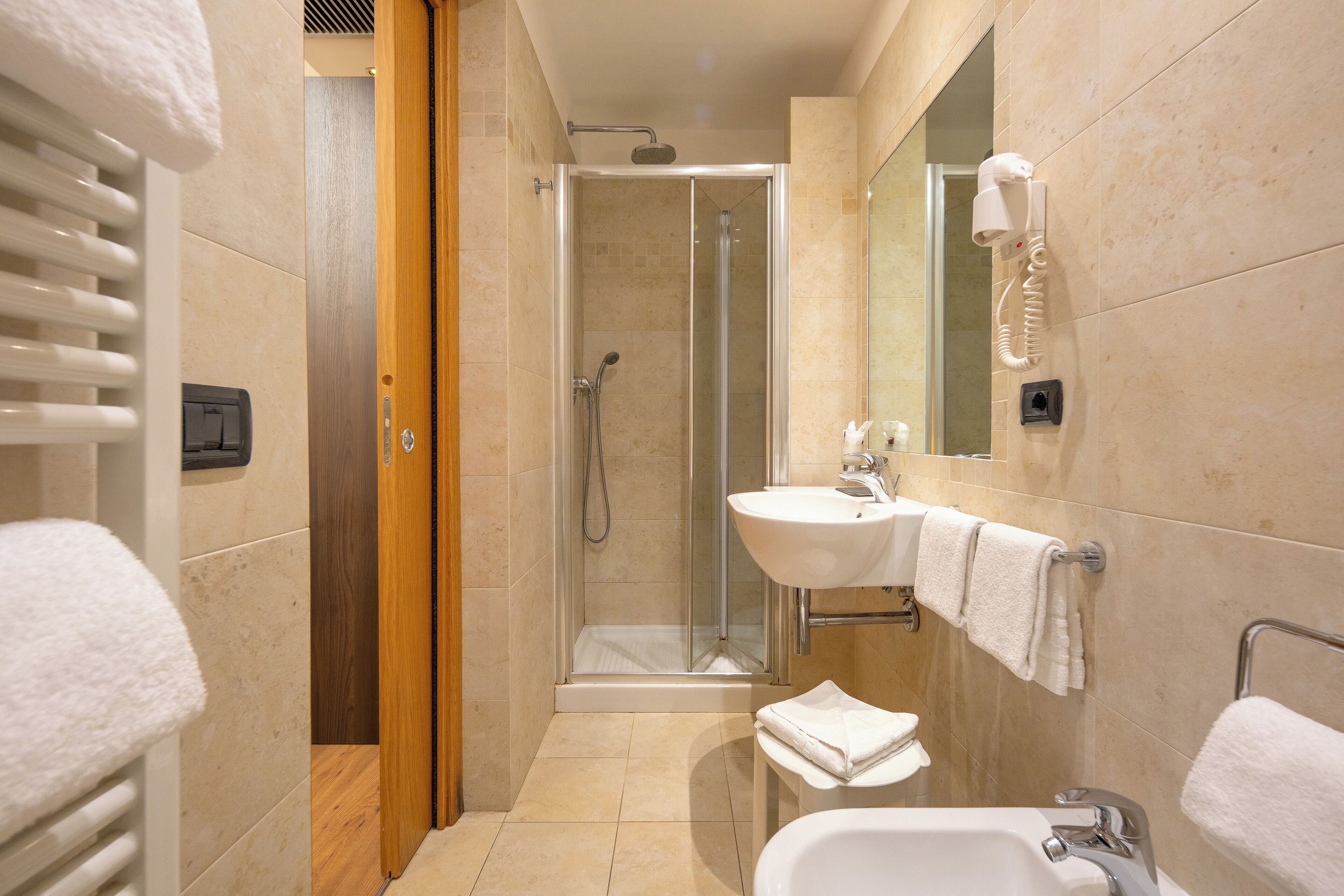 A modern bathroom with a glass-enclosed shower, a sink with a mirror, and a bathtub.