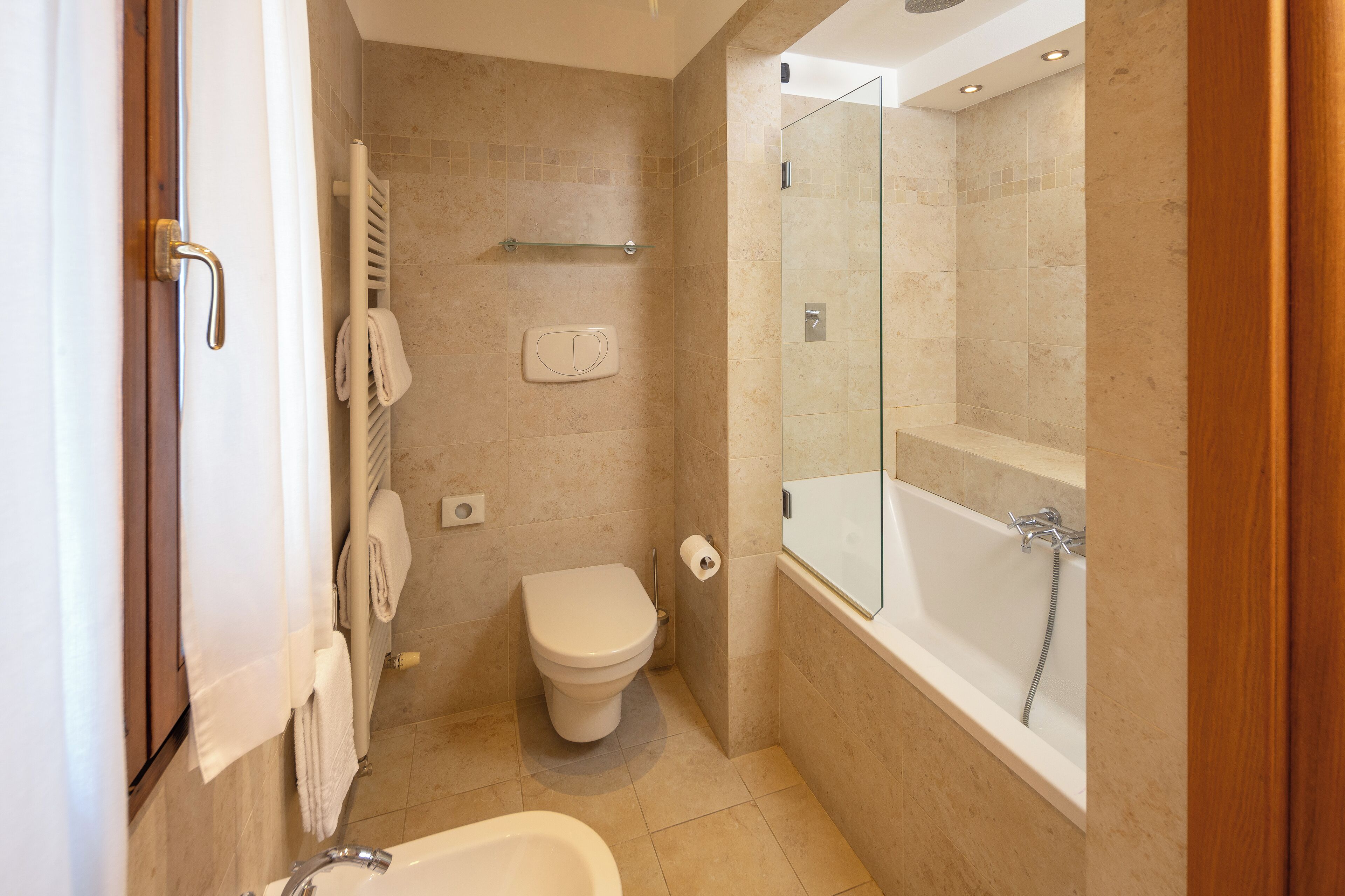 A modern bathroom with a toilet, sink, and bathtub.