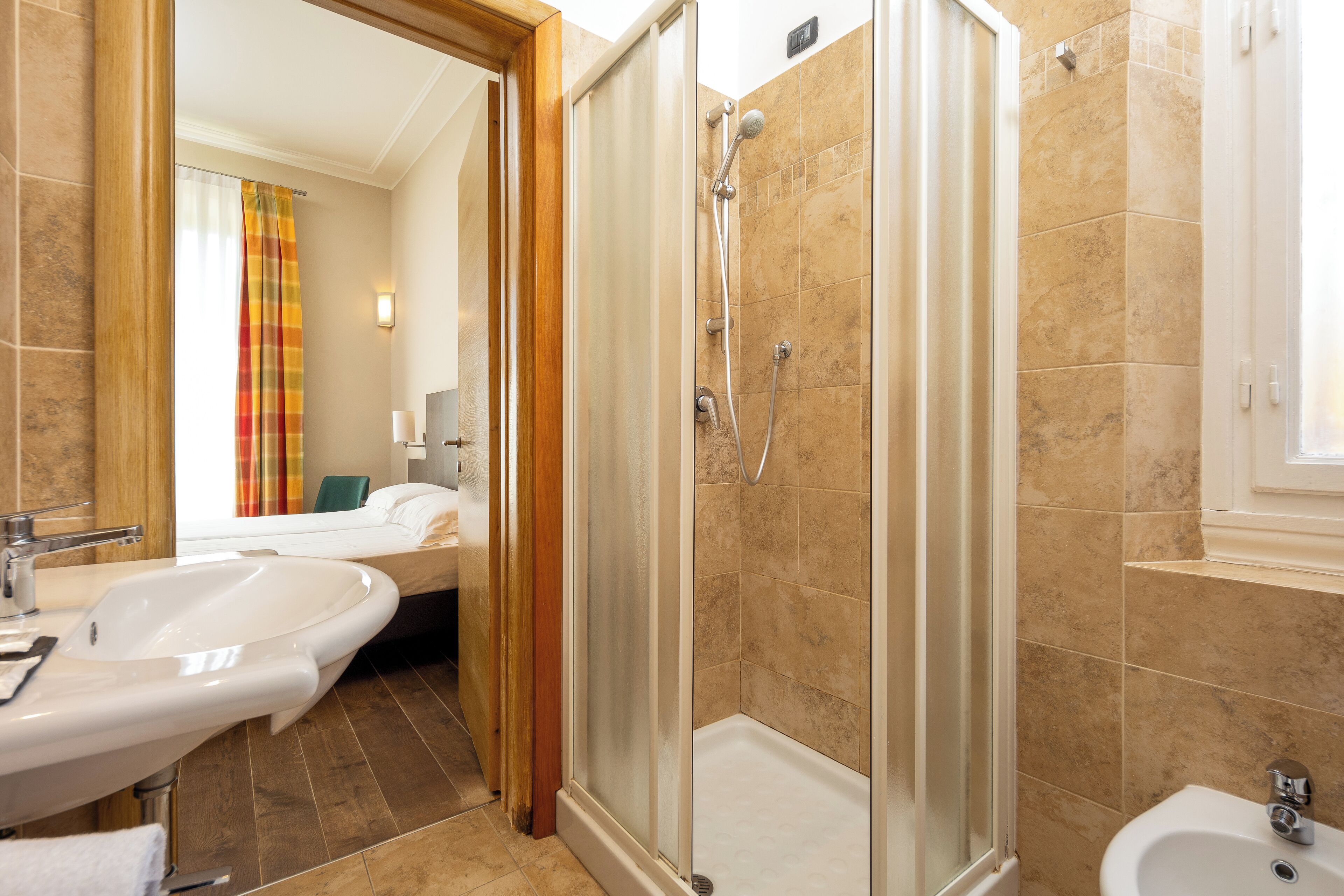 Ein Badezimmer mit Dusche, Waschbecken und Bidet.