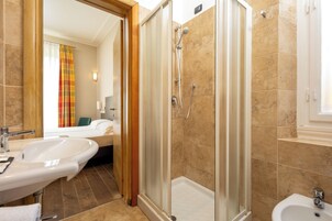 Un bagno con doccia, lavabo e bidet.