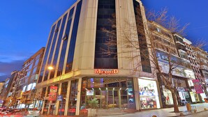 Un hôtel reconnaissable à son grand panneau « Madrid », à ses larges baies vitrées et à son emplacement en angle, avec un arbre devant.