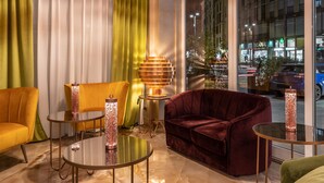 Een moderne hotel lobby met een groot raam, een ronde tafel en een bank.