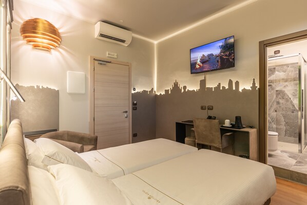 A hotel room with two beds, a desk, a chair, a TV, and a shower area.
