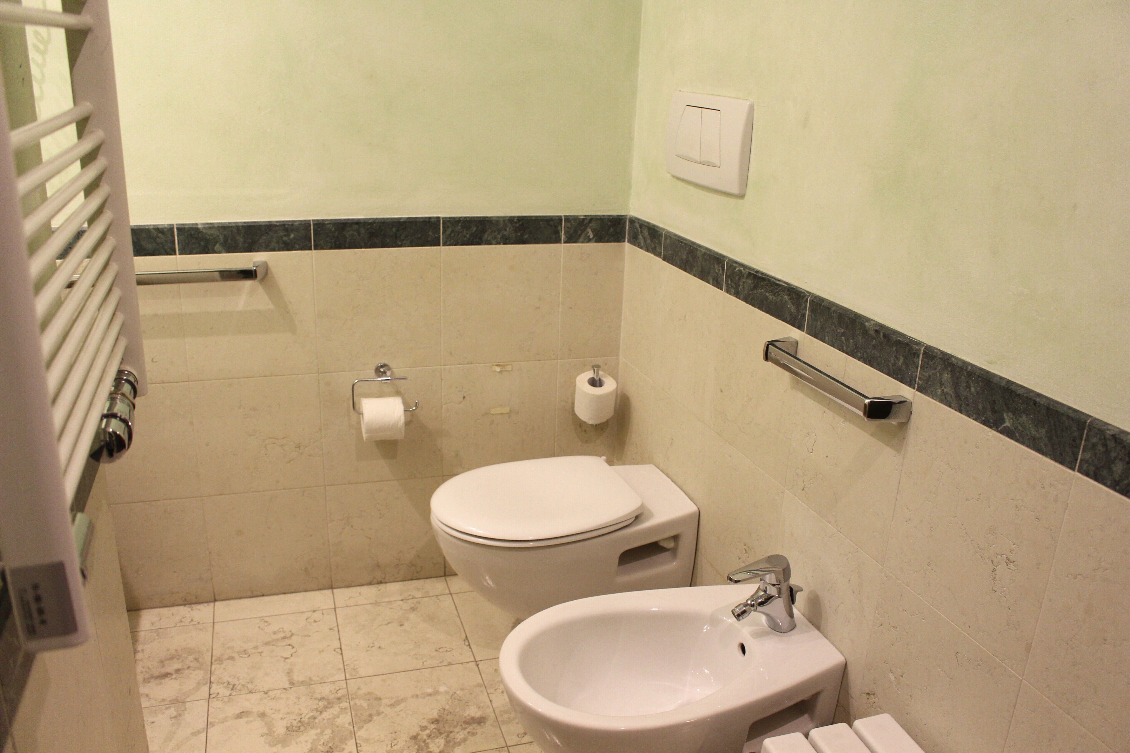 A small bathroom with a toilet, bidet, and sink.