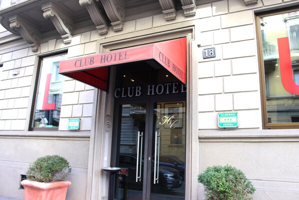 Welcome to the Club Hotel, where guests can enter through the glass door with a metal handle.