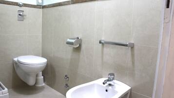 Une salle de bain équipée de toilettes, d’un lavabo et d’un porte-serviettes.