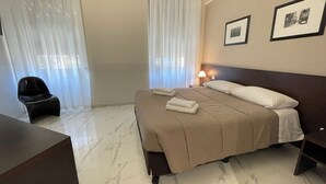 A hotel room with a bed, a desk, a chair, and two framed pictures on the wall. - Hotel Club (Milan)