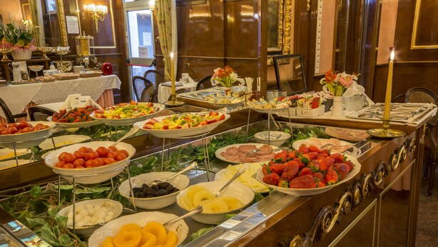 A buffet with various fruits and meats. - Hotel Vittoria (Milan)