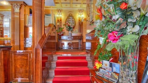 A grand staircase with red carpet leading to a reception area. - Hotel Vittoria (Milan)