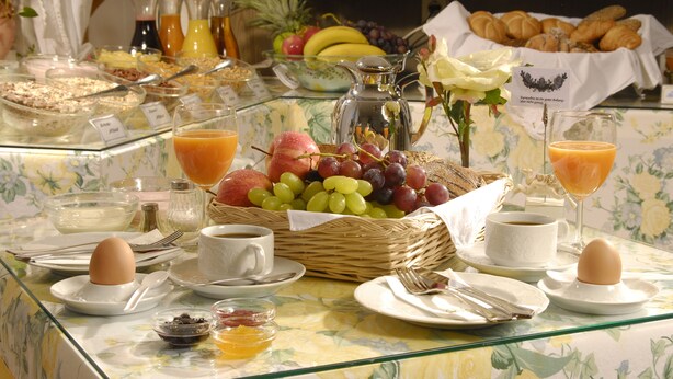 A breakfast buffet with various food items, including fruits, pastries, and beverages.