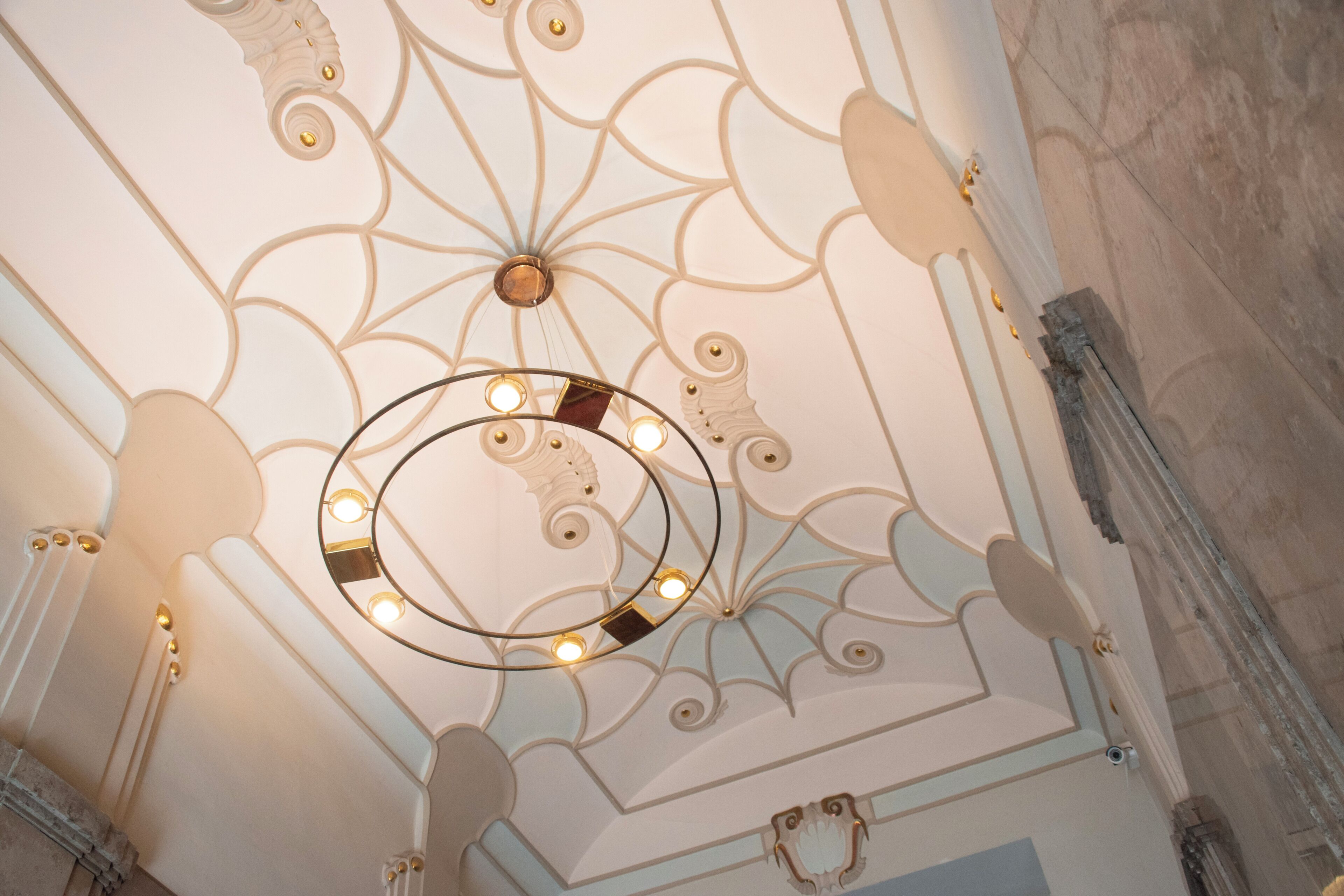 A ceiling with intricate patterns and a circular light fixture.