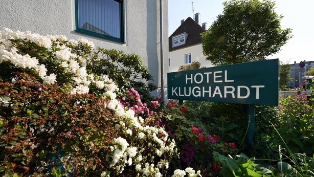 Señal del Hotel Klughardt con un jardín al frente.