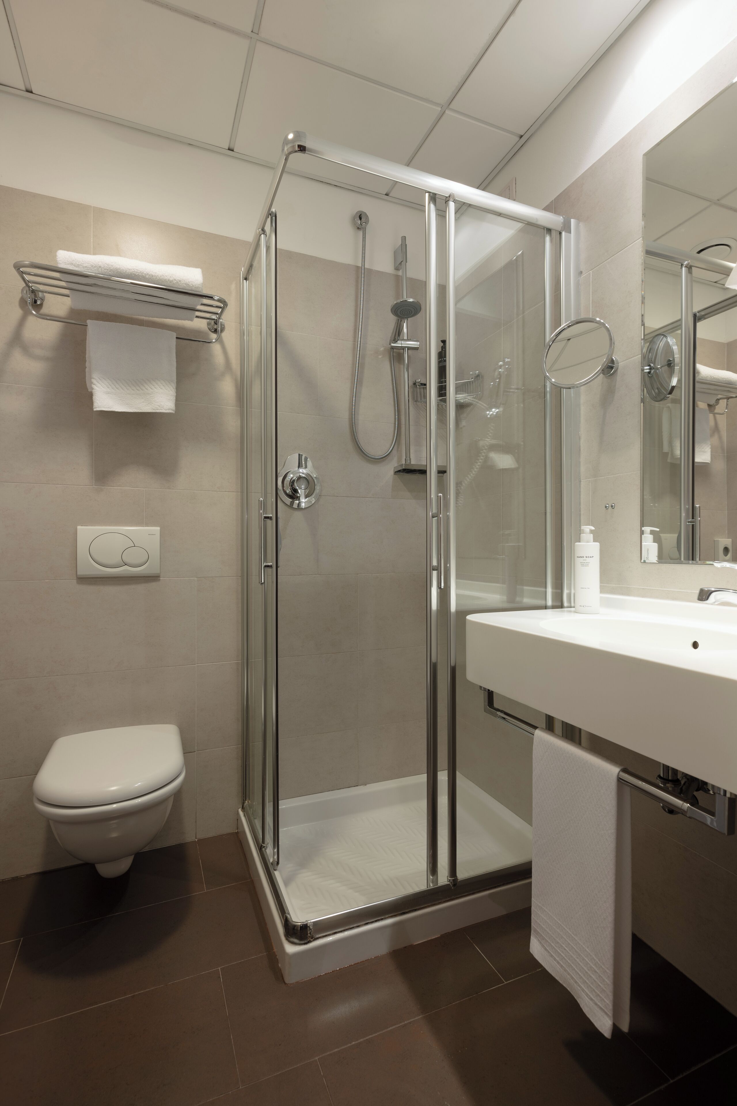 Une salle de bain moderne avec une douche à parois de verre, un lavabo blanc et des toilettes.