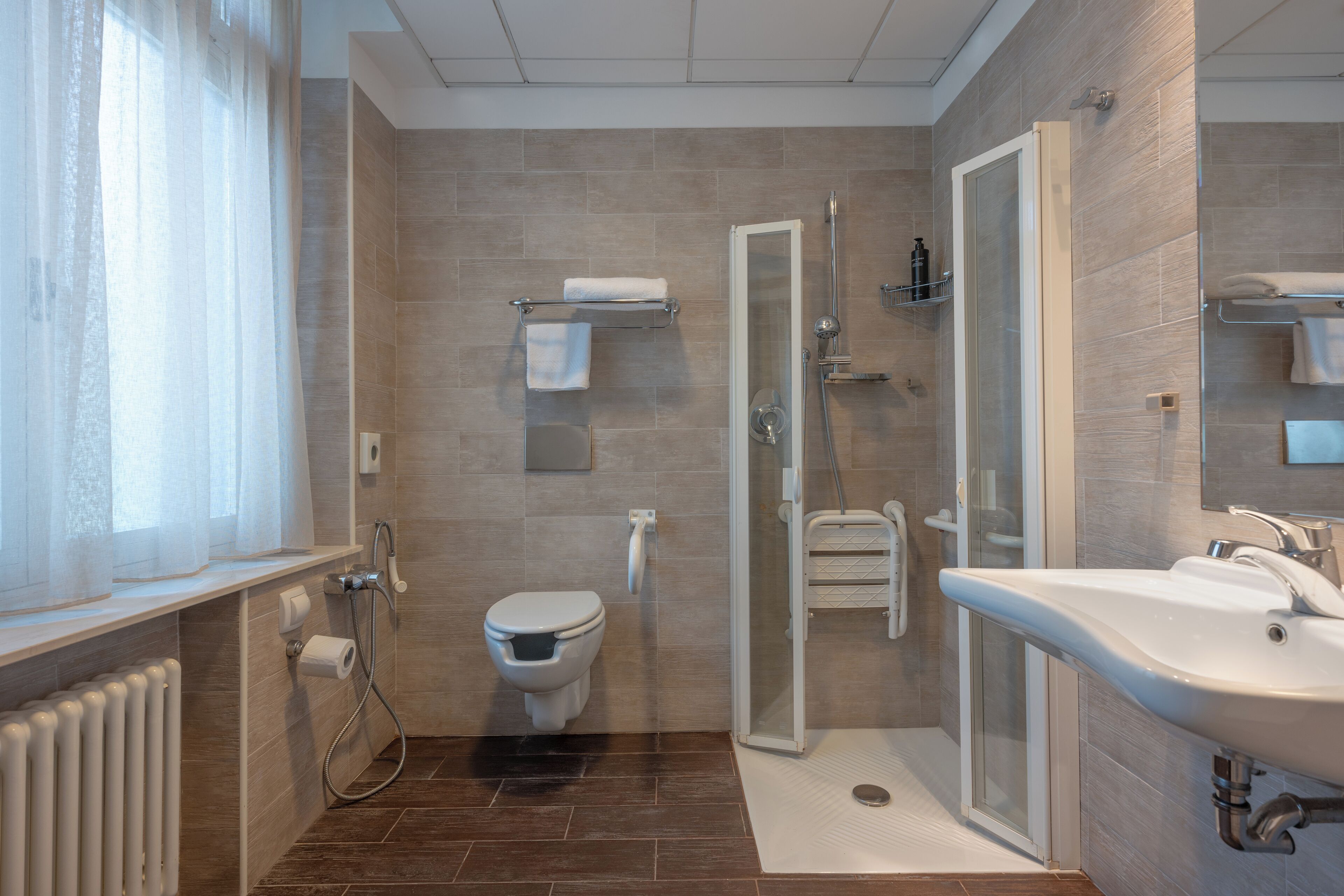 A modern bathroom with a toilet, shower, and sink.