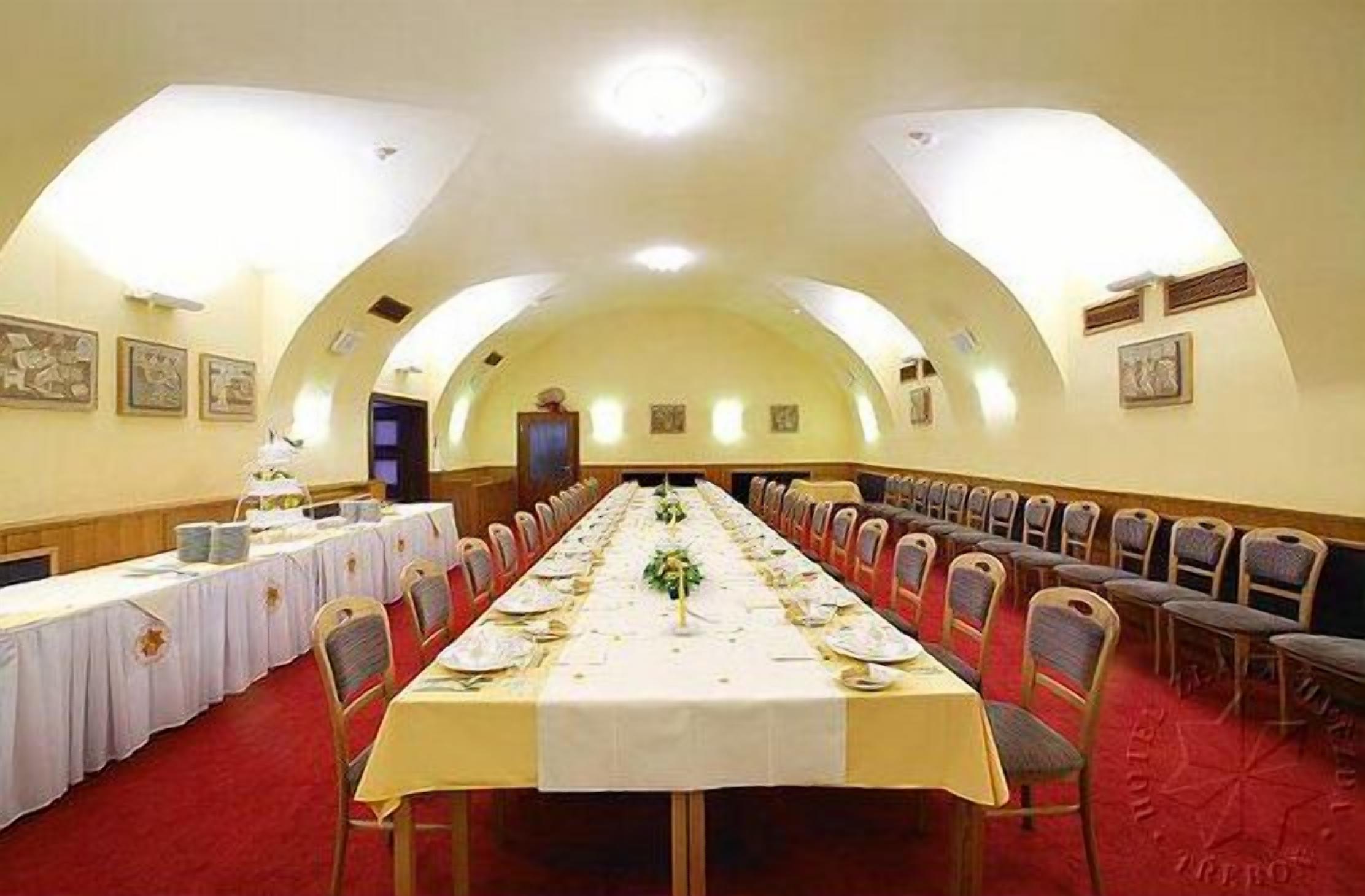 A long banquet table set for a formal event, with chairs arranged on both sides.