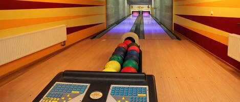 A bowling alley with a brightly colored wall and a bowling lane.