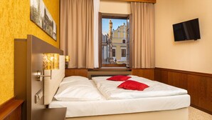 A hotel room with a bed, a TV, and a window with curtains. - Hotel Zlata Hvezda Trebon (Trebon)