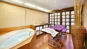 A modern bathroom with a large bathtub, a wooden vanity, a massage table, and a large woven basket. - Hotel Zlata Hvezda Trebon (Trebon)