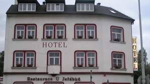 Un edificio a più piani con un cartello che indica “HOTEL” e “Restaurant U Jetáblka” nella parte inferiore.