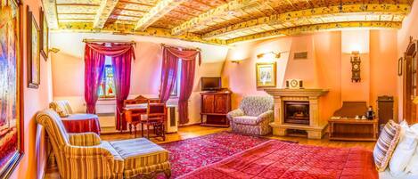 Una sala de estar acogedora con chimenea, televisión y comedor con mesa y sillas.