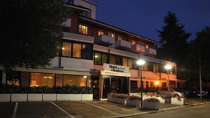 Een hotel met een modern design, bestaande uit een gebouw in twee verdiepingen, een overdekte entree en een parkeerplaats.