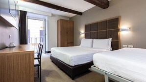Ein Hotelzimmer mit Bett, Nachttisch, Kleiderschrank und Blick ins Freie.