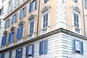 A building with multiple windows, some with shutters, and a sign that reads "Hotel D'Ancona." - Hotel Picasso (Rome)