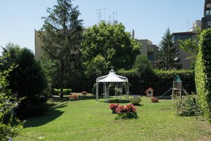 Un parco con un padiglione, un'area giochi e vegetazione circostante.
