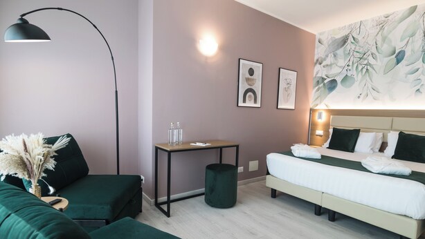 Una habitación de hotel moderna con una cama, un escritorio, una silla y una lámpara.