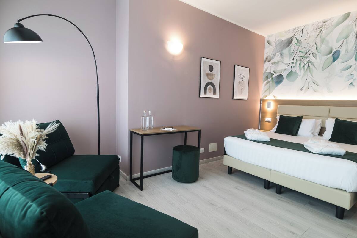 Ein modernes Hotelzimmer mit Bett, Schreibtisch, Stuhl und Lampe.