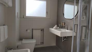 Un baño moderno con bañera, inodoro, lavabo y ducha.