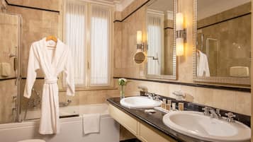 Un bagno con due lavandini, una vasca e uno specchio grande.