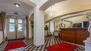 A lobby with checkered flooring, red carpets, a reception desk, and a statue. - Hotel Graf Stadion (Vienna)