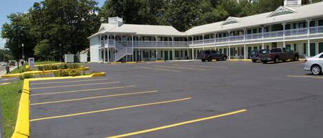 Een motel met een centrale binnenplaats, meerdere balkons en een parkeerplaats.