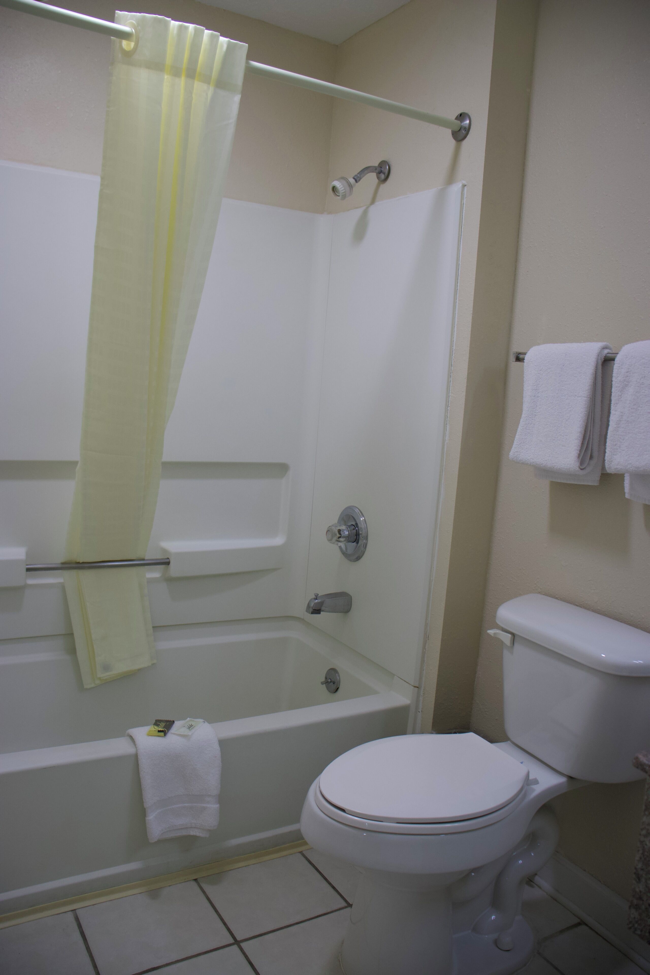 Une salle de bain avec une baignoire, des toilettes et un rideau de douche.
