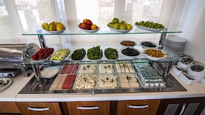 A buffet with various food items and utensils.