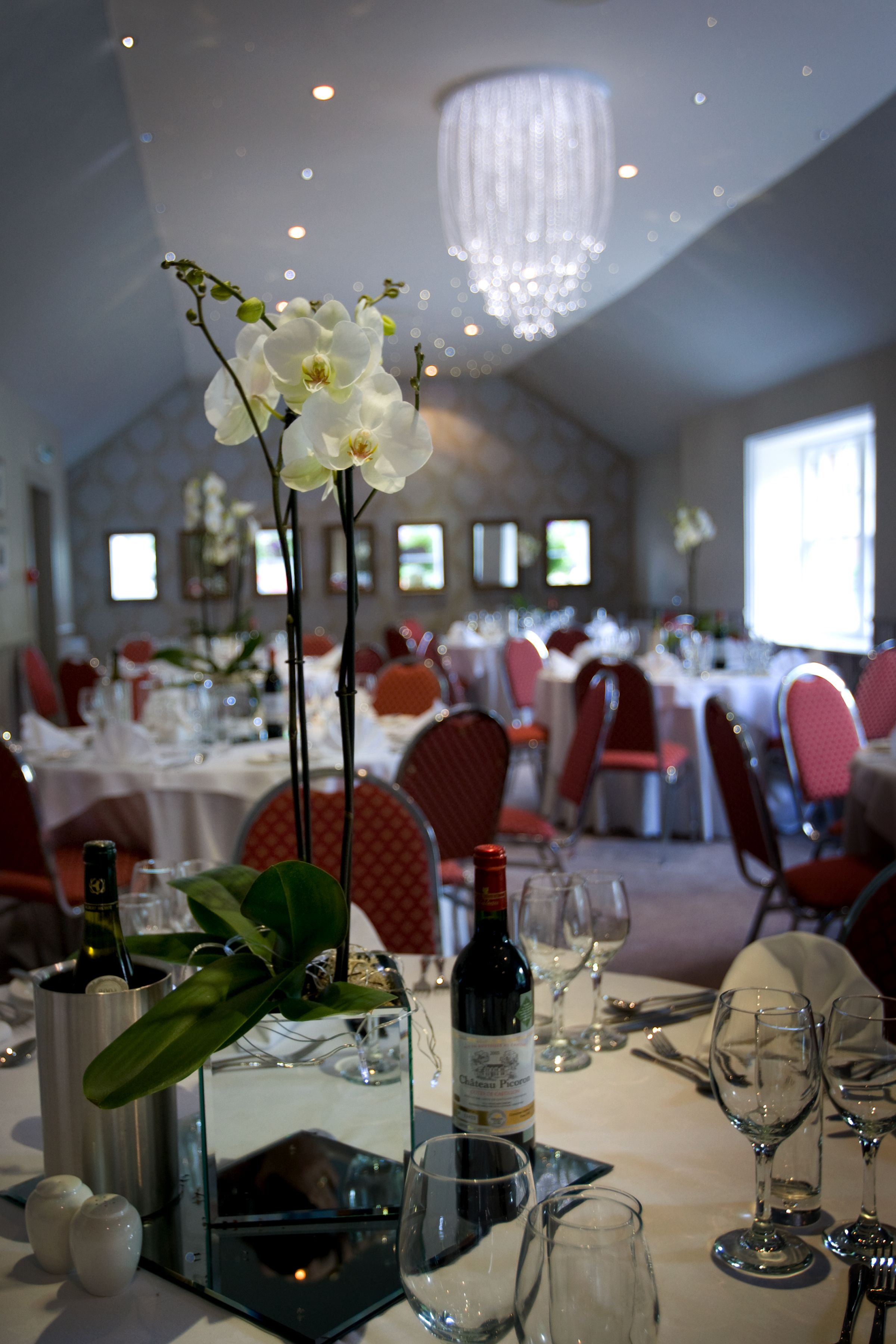 A dining area with tables set for a meal, including wine glasses, plates, and cutlery.
